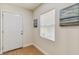 Inviting entryway featuring a bright white door, neutral walls, and beach-themed artwork at 8704 N Brooks St, Tampa, FL 33604