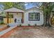 Charming home with front porch, natural wood post accents, fresh paint, and landscaped front yard at 8704 N Brooks St, Tampa, FL 33604