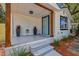Charming front porch with stained wood pillars, modern planters, and a blue front door at 8704 N Brooks St, Tampa, FL 33604