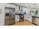 Bright kitchen boasts stainless steel appliances, quartz countertops, and modern white cabinetry at 8704 N Brooks St, Tampa, FL 33604