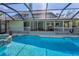 Exterior view of screened pool and covered porch showcasing the home's backyard at 8755 Ogleby Creek Rd, Myakka City, FL 34251
