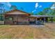 Rustic barn featuring wood siding, metal roof, and an open-air shelter, set in a natural landscape with a sunny sky at 8755 Ogleby Creek Rd, Myakka City, FL 34251