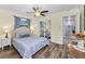 Bedroom with wood floors, patterned bedspread, and access to another room at 8755 Ogleby Creek Rd, Myakka City, FL 34251