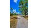 Inviting one-story home with a wraparound porch, set back from a long driveway with mature trees at 8755 Ogleby Creek Rd, Myakka City, FL 34251