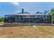 Rear exterior showcasing screened pool and patio area and chimney of this home set on an expansive lot at 8755 Ogleby Creek Rd, Myakka City, FL 34251