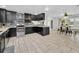 Kitchen showcasing black cabinetry, mosaic backsplash, stainless steel appliances, and an adjacent dining area at 8755 Ogleby Creek Rd, Myakka City, FL 34251