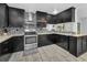 Updated kitchen with black cabinets, stainless steel appliances and a stylish backsplash, perfect for modern living at 8755 Ogleby Creek Rd, Myakka City, FL 34251