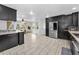 Spacious kitchen featuring stainless steel appliances, black cabinets, and a view into the dining area at 8755 Ogleby Creek Rd, Myakka City, FL 34251