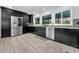 Modern kitchen with stainless steel appliances, dark cabinetry, and tile backsplash at 8755 Ogleby Creek Rd, Myakka City, FL 34251