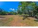 Expansive lot featuring mature trees and wooden outbuilding on a sunny day at 8755 Ogleby Creek Rd, Myakka City, FL 34251