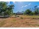 Rear view of fenced, expansive lot and rear exterior of home showcasing screened patio at 8755 Ogleby Creek Rd, Myakka City, FL 34251