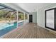 Covered porch with wood flooring and access to screened pool and outdoor space at 8755 Ogleby Creek Rd, Myakka City, FL 34251