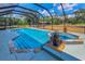 Screened pool and spa area featuring decorative rock waterfall detail with view of wooden outbuilding on expansive lot at 8755 Ogleby Creek Rd, Myakka City, FL 34251