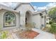 Close up of the home's light colored exterior with arched windows and entryway at 9422 Clover Glen Dr, Riverview, FL 33569