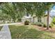 Charming front exterior of the home featuring a well-manicured lawn, mature trees, and a welcoming entrance at 9422 Clover Glen Dr, Riverview, FL 33569