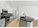 A view of the kitchen with white and gray cabinets and a stainless steel stove at 9422 Clover Glen Dr, Riverview, FL 33569