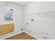 Laundry room with bright walls, wood floors, wire shelving, and a mounted folding table at 9422 Clover Glen Dr, Riverview, FL 33569