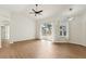 Spacious living room featuring wood floors, white walls, sliding glass doors, and a modern ceiling fan at 9422 Clover Glen Dr, Riverview, FL 33569