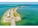 Stunning aerial view of a coastal bridge and the surrounding ocean with clear turquoise water at 946 Highland Ave # 24, Dunedin, FL 34698
