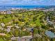 Expansive aerial view of a meticulously maintained golf course, featuring lush greens and picturesque lakes at 946 Highland Ave # 24, Dunedin, FL 34698
