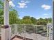 Private balcony surrounded by lush green trees and bushes under a bright blue sky at 946 Highland Ave # 24, Dunedin, FL 34698