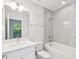 Bathroom with white tub and tiled shower and modern vanity with mirror, chrome faucet and lighting at 946 Highland Ave # 24, Dunedin, FL 34698
