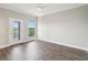 Bright bedroom featuring hardwood floors, neutral paint, ceiling fan, natural light, and a balcony at 946 Highland Ave # 24, Dunedin, FL 34698