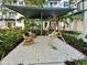 Well-maintained community courtyard with a hammock swing, rocking chairs, and lush landscaping at 946 Highland Ave # 24, Dunedin, FL 34698