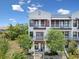 Beautiful townhome with white trim, a pair of balconies, and mature trees in the front yard at 946 Highland Ave # 24, Dunedin, FL 34698