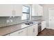 White kitchen with stainless steel appliances, gray backsplash, and granite countertops at 946 Highland Ave # 24, Dunedin, FL 34698