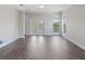 Light-filled living room with laminate floors, ceiling fan and access to a balcony at 946 Highland Ave # 24, Dunedin, FL 34698