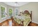 Bedroom boasts a wooden bed frame, hardwood floors, and views of the landscaped yard at 9818 Tree Tops Lake Rd, Tampa, FL 33626