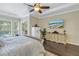 Bright bedroom with a king bed, ceiling fan, patio access, mounted TV, and dark wood floors at 9818 Tree Tops Lake Rd, Tampa, FL 33626