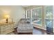 Bedroom sitting area with a chaise lounge, hardwood floors, and windows overlooking the pool at 9818 Tree Tops Lake Rd, Tampa, FL 33626