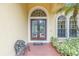 Up close shot of the home's front door and entryway with brickwork and landscaping at 9818 Tree Tops Lake Rd, Tampa, FL 33626