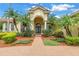Lovely Mediterranean-style home with mature palms, manicured landscaping, and a brick walkway at 9818 Tree Tops Lake Rd, Tampa, FL 33626