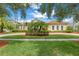 Beautiful Mediterranean-style home features lush landscaping, large windows, and barrel tile roof at 9818 Tree Tops Lake Rd, Tampa, FL 33626
