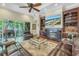 Open-concept living room with fireplace, built-in bar, and access to the outdoor lanai at 9818 Tree Tops Lake Rd, Tampa, FL 33626