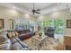 Spacious living room featuring a large leather sectional and views of the outdoor lanai at 9818 Tree Tops Lake Rd, Tampa, FL 33626