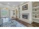 Elegant living room featuring a fireplace, built-in shelving, and arched doorways at 9818 Tree Tops Lake Rd, Tampa, FL 33626