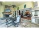 Covered patio with stone fireplace, TV, dining table, grill and view to the main living area provides a relaxing outdoor space at 9818 Tree Tops Lake Rd, Tampa, FL 33626