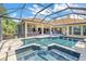 Expansive pool and spa area enclosed in a screened lanai, offering plenty of room for relaxation at 9818 Tree Tops Lake Rd, Tampa, FL 33626