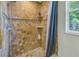 Shower featuring beautiful travertine tile, shower curtain, and window at 9818 Tree Tops Lake Rd, Tampa, FL 33626
