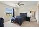Bright bedroom featuring a ceiling fan, plush carpet, and a large window with natural light at 9960 Hound Chase Dr, Gibsonton, FL 33534