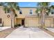 Exterior of a two-story home showing the garage, palm trees, and well-manicured landscaping at 9960 Hound Chase Dr, Gibsonton, FL 33534