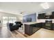 Open-concept kitchen and living area with dark cabinets, granite countertops, and modern appliances at 9960 Hound Chase Dr, Gibsonton, FL 33534