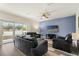 Cozy living room boasts modern flooring, a ceiling fan, and a sliding glass door to the backyard at 9960 Hound Chase Dr, Gibsonton, FL 33534