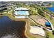 Aerial view of community amenities, featuring a pool, playground, and outdoor stage by a lake at 11013 Leland Groves Dr, Riverview, FL 33579