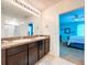 Bathroom featuring double sinks, granite countertops, and a doorway leading into the adjacent bedroom at 11013 Leland Groves Dr, Riverview, FL 33579