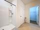 Modern bathroom features a tiled shower and a view into a spacious walk-in closet, blending style and functionality at 11013 Leland Groves Dr, Riverview, FL 33579